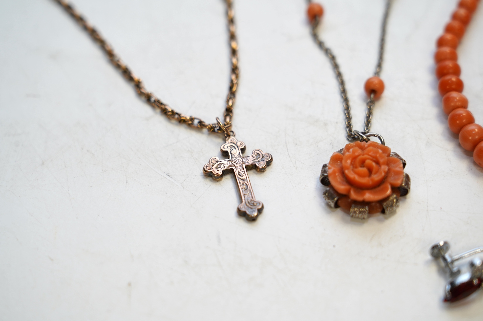 A Victorian yellow metal crucifix on a yellow metal chain, a coral necklace and other assorted jewellery. Condition - fair to poor